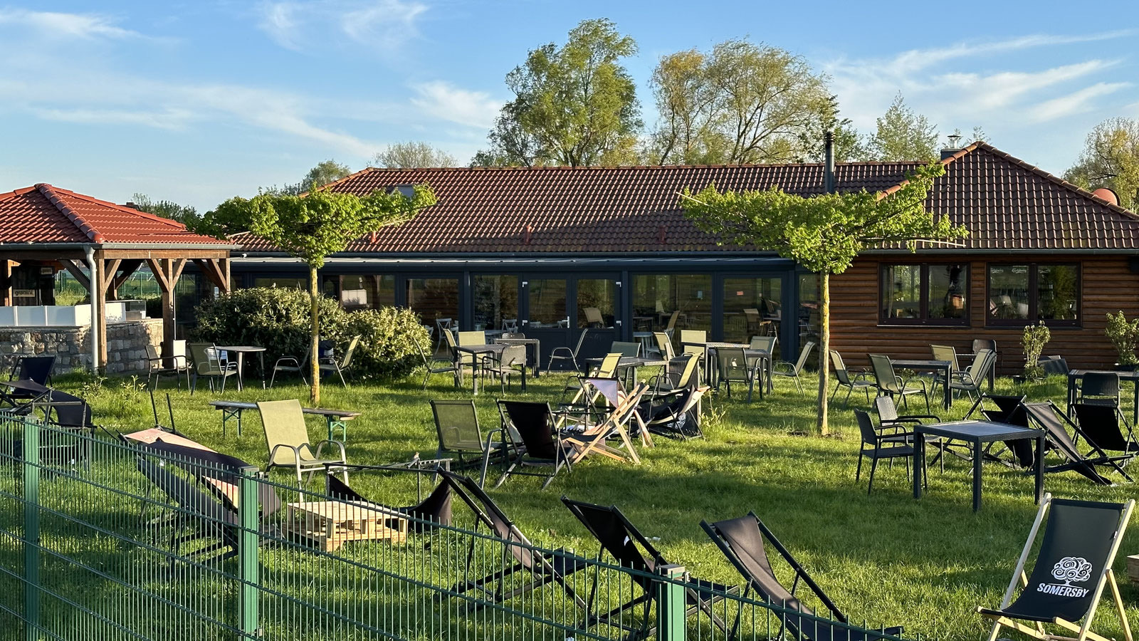 Biergarten der Landebahn 3.0 mit Liegestühlen und Holzbänken im Sonnenschein